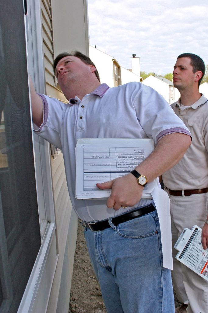 Two professionals inspecting a house